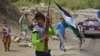 Children of local Afghan residents carrying hunting rifles and a flag walk through a road in Bandejoy area of Dara district in Panjshir province on August 21, 2021, days after the Taliban stunning takeover of Afghanistan.