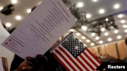 Warga negara baru berdiri selama upacara naturalisasi Layanan Kewarganegaraan dan Imigrasi AS (USCIS) di Museum dan Perpustakaan Masyarakat Sejarah New York di Manhattan, New York, AS, 10 April 2017. (Foto: REUTERS/Shannon Stapleton)
