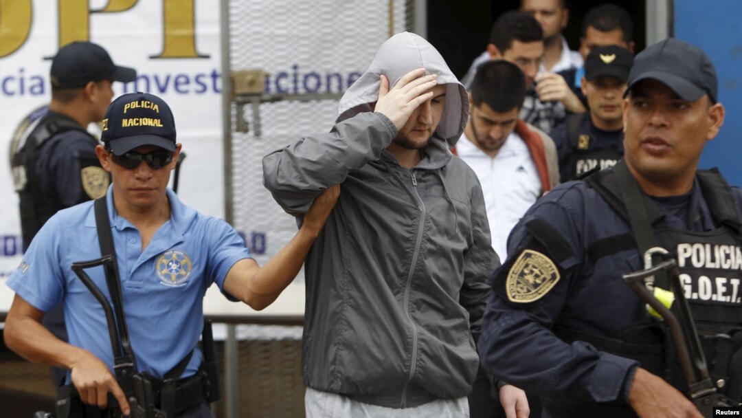 Police in Tegucicalpa escort one of five Syrians ordered jailed after they were found to have used stolen Greek passports to enter Honduras, Nov. 20, 2015.