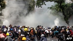 Protesters react after police fired tear gas during a demonstration against the military coup in Mandalay, Myanmar, March 3, 2021. 
