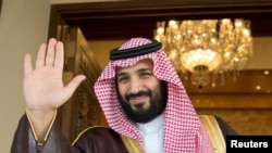 FILE - Saudi Crown Prince Mohammed bin Salman waves as he meets with a visiting official in Riyadh, Saudi Arabia, April 11, 2017.