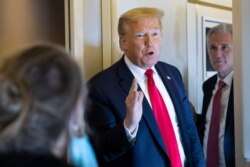 President Donald Trump, with House Minority Leader Kevin McCarthy of Calif., speaks with reporters while in air en route to Andrews Air Force Base, May 30, 2020, in flight.
