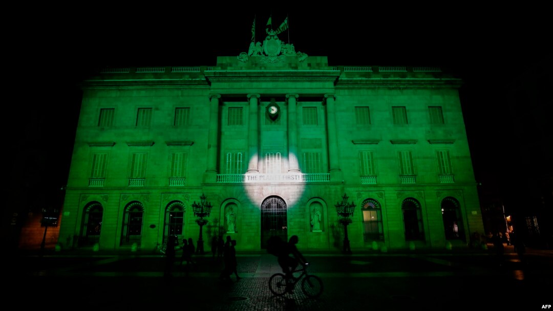 FILE - The City Hall of Barcelona is illuminated in green in support of the Paris climate accord aiming to meet greenhouse gas emission targets, in Barcelona, Spain, June 2, 2017.
