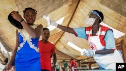 Pessoas vindas da Rep. Dem. do Congo vistas por técnicos de saúde para medir a temperatura devido ao ébola, na fronteira de Mpondwe no Uganda. 14 Junho, 2019.