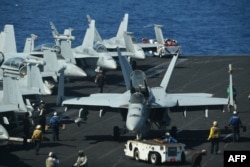 Sailors preapre FA-18 Hornet fighter jets for takeoff during routine training aboard the U.S. aircraft carrier Theodore Roosevelt in the South China Sea, April 10, 2018.