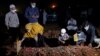 Seorang perempuan dan anak-anaknya saat pemakaman suaminya yang meninggal akibat COVID-19 di Bekasi, 27 Juli 2021. (Foto: Willy Kurniawan/Reuters)