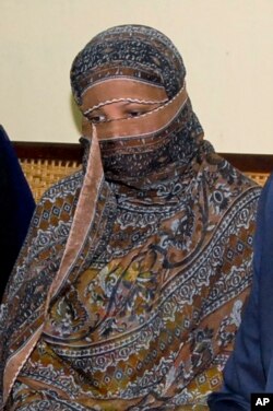 FILE - Pakistani Christian woman Asia Bibi, listens to Governor of Pakistani Punjab Province Salman Taseer, unseen, at a prison in Sheikhupura near Lahore, Nov. 20, 2010.