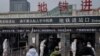 北京地鐵站保安人員身穿防護服檢測地鐵乘客的體溫。 （2020年1月27日）