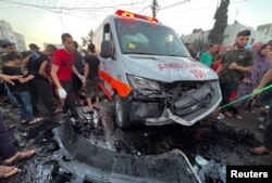 Warga Palestina memeriksa kerusakan setelah konvoi ambulans dihantam, di pintu masuk rumah sakit Shifa di Kota Gaza, 3 November 2023. (Foto: REUTERS/Mohammed Al-Masri)