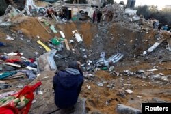 Seorang warga Palestina melihat lokasi serangan Israel terhadap rumah-rumah di tengah konflik yang sedang berlangsung antara Israel dan kelompok Islam Palestina Hamas, di Rafah di selatan Jalur Gaza, 12 Desember 2023. (Foto: REUTERS/Mohammed Salem)