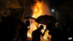 香港中文大學的學生在與警察的衝突中走過火堆。 （2019年11月12日）