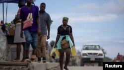 Seseorang membawa kontainer berisi bensin untuk dijual di jalanan Cap-Haitien, Haiti, 29 April 2024. (Foto: REUTERS/Ricardo Arduengo)