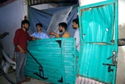 FILE - Afghans inspect damage to the Ahmadi family house after a U.S. drone strike in Kabul, Afghanistan, Aug. 29, 2021.