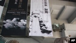 台北市立美术馆大厅悬挂的巨幅海报上写着“艾未未·缺席”，人像的头也缺席了。