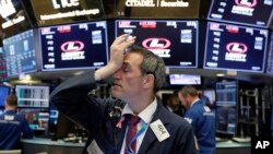 A trader works on the floor of the New York Stock Exchange, Oct. 23, 2018. Stocks opened sharply lower on Wall Street following big drops in Asia and Europe.