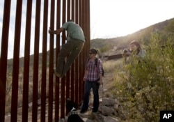 FILE - In this May 11, 2016, photo, former construction foreman Tim Foley shows how to climb a section of the border wall separating Mexico and the United States.
