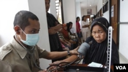 Seorang petugas kesehatan memeriksa kesehatan seorang ibu di klinik umum di Jakarta. Jika RUU jaminan sosial disahkan maka setiap warga negara akan memiliki akses bagi kesehatan, pendidikan dan kebutuhan dasar.