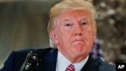 President Donald Trump pauses as he answers questions in the lobby of Trump Tower in New York, Aug. 15, 2017.
