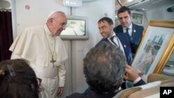 Papa Franja prima poklon od novinara tokom leta iz Abu Dabija ka Rimu, 5. februara 2019.