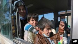 Dua anak laki-laki Yazidi, yang menderita infeksi setelah ditahan oleh kelompok Negara Islam (ISIS) menunggu bersama ibunya dalam bus yang akan pergi ke kota Kurdi, Dohuk di Irak. (Foto: Ilustrasi)