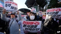 Anggota oposisi utama Partai Demokrat menggelar unjuk rasa menentang Presiden Korea Selatan Yoon Suk Yeol di depan Majelis Nasional di Seoul, Korea Selatan, Rabu, 4 Desember 2024. Spanduk bertuliskan "Mari kita makzulkan Yoon Suk Yeol." (Ahn Young-joon/AP)