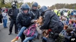 Police officers carry away a demonstrator after police stop a protest against the German government's coronavirus restrictions, in Berlin, Germany, April 21, 2021.