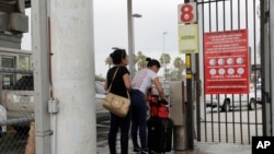 FILE - Josseline Garcia, 20, and Jennifer Garcia, 24, sisters from Guatemala seeking asylum, cross a bridge to a port of entry in to the United States from Matamoros, Mexico, June 20, 2018, in Brownsville, Texas.