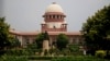 FILE - A gardener works on the lawns of the Supreme Court in New Delhi, India, Aug. 22, 2017.