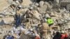 FILE - Civil defense members search for survivors at a site hit yesterday by what activists said were airstrikes carried out by the Russian air force in Idlib city, Syria, Dec. 21, 2015. 