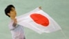 Yuzuru Hanyu of Japan poses with the national flag after he placed first in the men's free skate figure skating final following the flower ceremony at the Iceberg Skating Palace during the 2014 Winter Olympics, Feb. 14, 2014, in Sochi, Russia. 