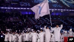 南北韓運動員星期五，在一面藍白相間象徵朝鮮統一旗幟的引領下進場。