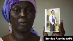 In this Monday, May 19, 2014 file photo, Martha Mark, the mother of kidnapped school girl Monica Mark cries as she displays her photo, in the family house, in Chibok, Nigeria.