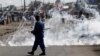 FILE - A policeman walks away after throwing a teargas canister at protesters rallying against Burundi President Pierre Nkurunziza and his bid for a third term, in Bujumbura, Burundi, June 2, 2015.