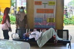 Seorang pasien berbaring di bangku saat menunggu untuk dirawat di ruang gawat darurat rumah sakit pemerintah Dr. Loekmono Hadi, di tengah pandemi COVID-19 di Kudus, provinsi Jawa Tengah, 2 Juni 2021.
