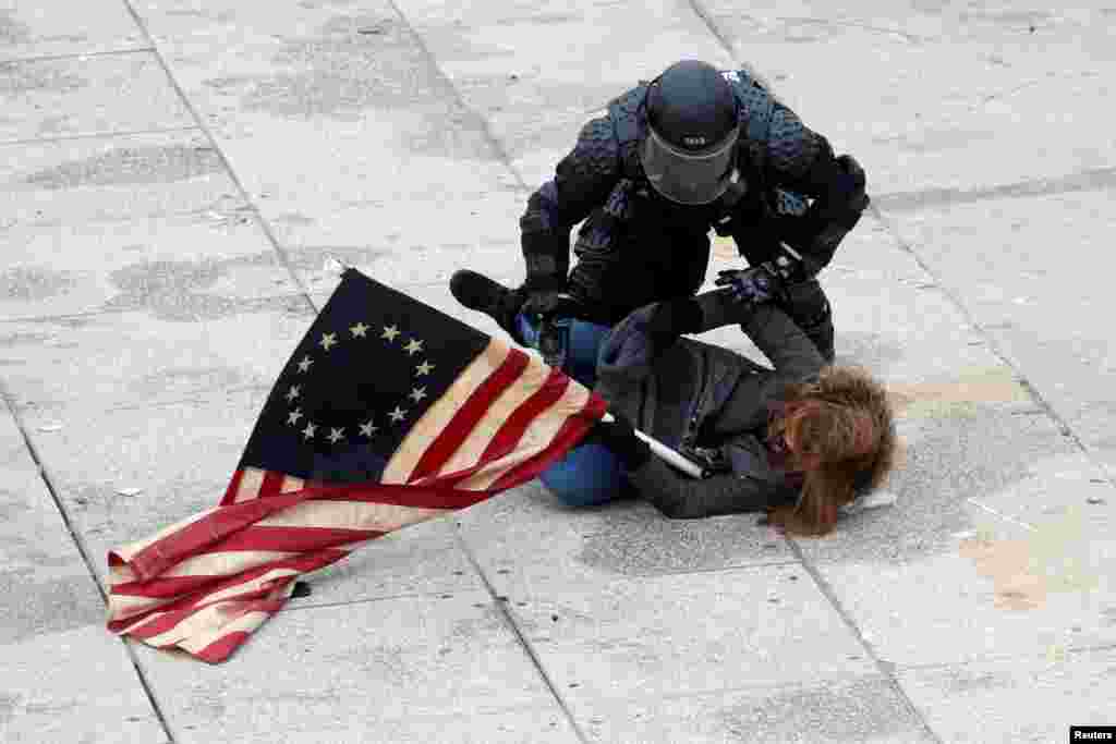 Um manifestante pró-Trump é detido pela polícia no Capitólio, depois de vários apoiantes do Presidente Trump terem invadido o Capitólio durante a cerimónia de confirmação do voto do Colégio Eleitoral. Washington DC, 6 de Janeiro, 2021.