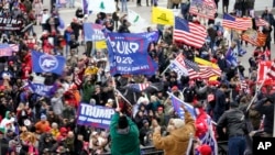 FILE - Rioters gather outside the US Capitol in Washington, on January 6, 2021.