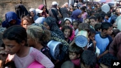 Warga Palestina antre untuk menerima distribusi bantuan makanan di kota Deir al-Balah (17/10), Jalur Gaza di tengah minimnya bantuan kemanusiaan di sana.