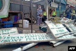 Polisi menurunkan papan nama di markas organisasi FPI (Front Pembela Islam) di Jakarta pada 30 Desember 2020. (Foto: AFP)