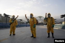 Municipal workers wait before spraying insecticide at Sambodrome in Rio de Janeiro, Brazil, Jan. 26, 2016.