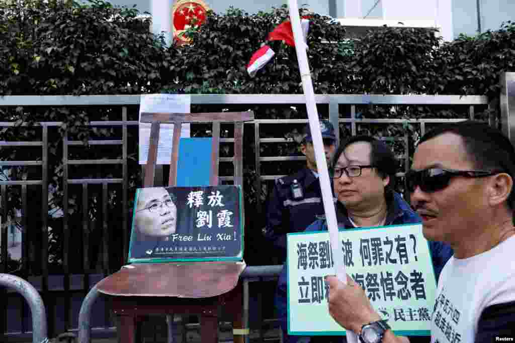 在圣诞节,香港抗议者在中联办大楼前摆放一张空椅子和刘晓波遗孀刘霞的照片,呼吁中国当局解除对刘霞的软禁。他们把圣诞帽扔进围栏。(2017年12月25日)
