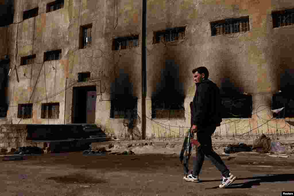 A man carrying a rifle searches for his cousin who was detained in Sednaya prison, which was known as a slaughterhouse under Syria's Bashar al-Assad rule, in Sednaya.