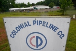 FILE - Tanker trucks are parked near the entrance of the Colonial Pipeline Company, May 12, 2021, in Charlotte, North Carolina. The company, which transports gasoline along the U.S. East Coast, was recently hit a by a ransomware attack.