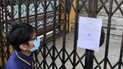 Seorang pengunjung membaca pemberitahuan penutupan sementara Istana Maimun di Kota Medan, untuk mencegah penyebaran virus corona, Rabu 18 Maret 2020. (Foto: Anugrah Andriansyah/VOA)