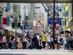 Para pejalan kaki mengenakan masker saat berjalan di pusat kota Tokyo, Jepang, di tengah pandemi COVID-19, di 14 Mei 2021. (REUTERS / Naoki Ogura)