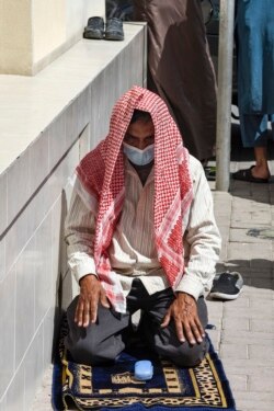 Seorang pria mengenakan masker saat salat Jumat di luar masjid di ibu kota Bahrain, Manama, di tengah pandemi COVID-19, 28 Februari 2020. (AFP)
