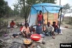 FILE - A man cooks a meal in his makeshift restaurant on the island of Bhasan Char in the Bay of Bengal, Bangladesh, Feb. 14, 2018.