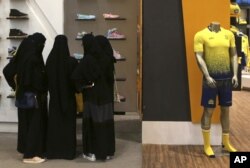 FILE - Saudi women shop at a mall in Riyadh, Saudi Arabia, Dec. 11, 2015. The kingdom has announced a projected budget deficit in 2016 as lower oil prices cut into the government's main source of revenue.