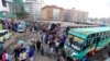 Passengers gather to board disinfected public transport buses as residents leave for the villages amid concerns over the spread of COVID-19 in downtown Nairobi, Kenya, March 25, 2020. 