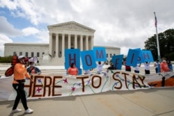 Deferred Action for Childhood Arrivals (DACA) recipient Roberto Martinez, left, celebrates with other DACA recipients in front of the Supreme Court on June 18, 2020, in Washington.