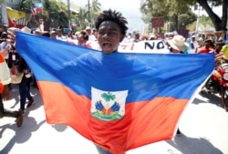 A demonstrator takes part in a march during a protest against Haiti's President Jovenel Moise, in Port-au-Prince, Haiti February 14, 2021. REUTERS/Jeanty Junior Augustin TPX IMAGES OF THE DAY